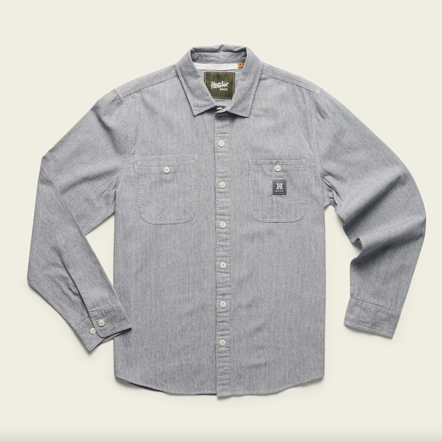 Gray button-up shirt with a brand label on a beige background