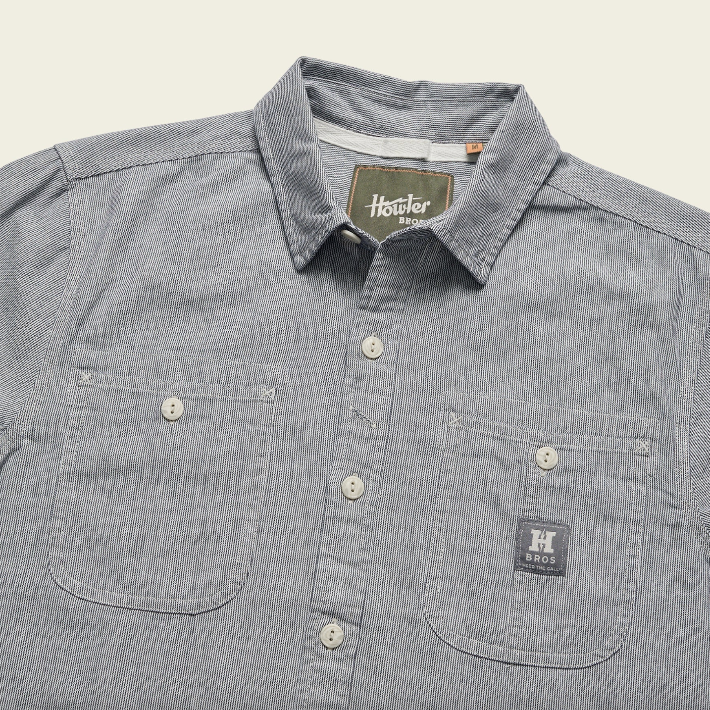 Gray striped shirt with a brand label on a beige background